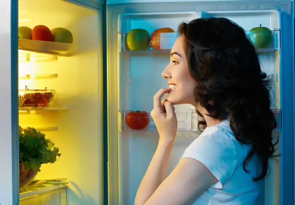 la ragazza guarda nel frigorifero durante la rapida perdita di peso