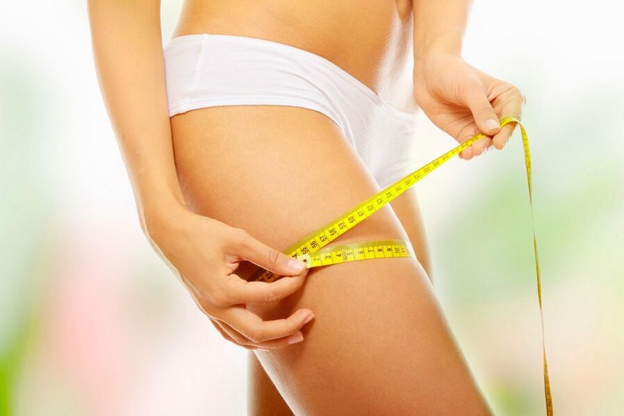 La ragazza misura il suo volume della coscia