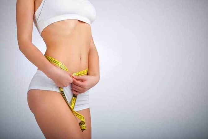 La ragazza snella misura il volume della vita